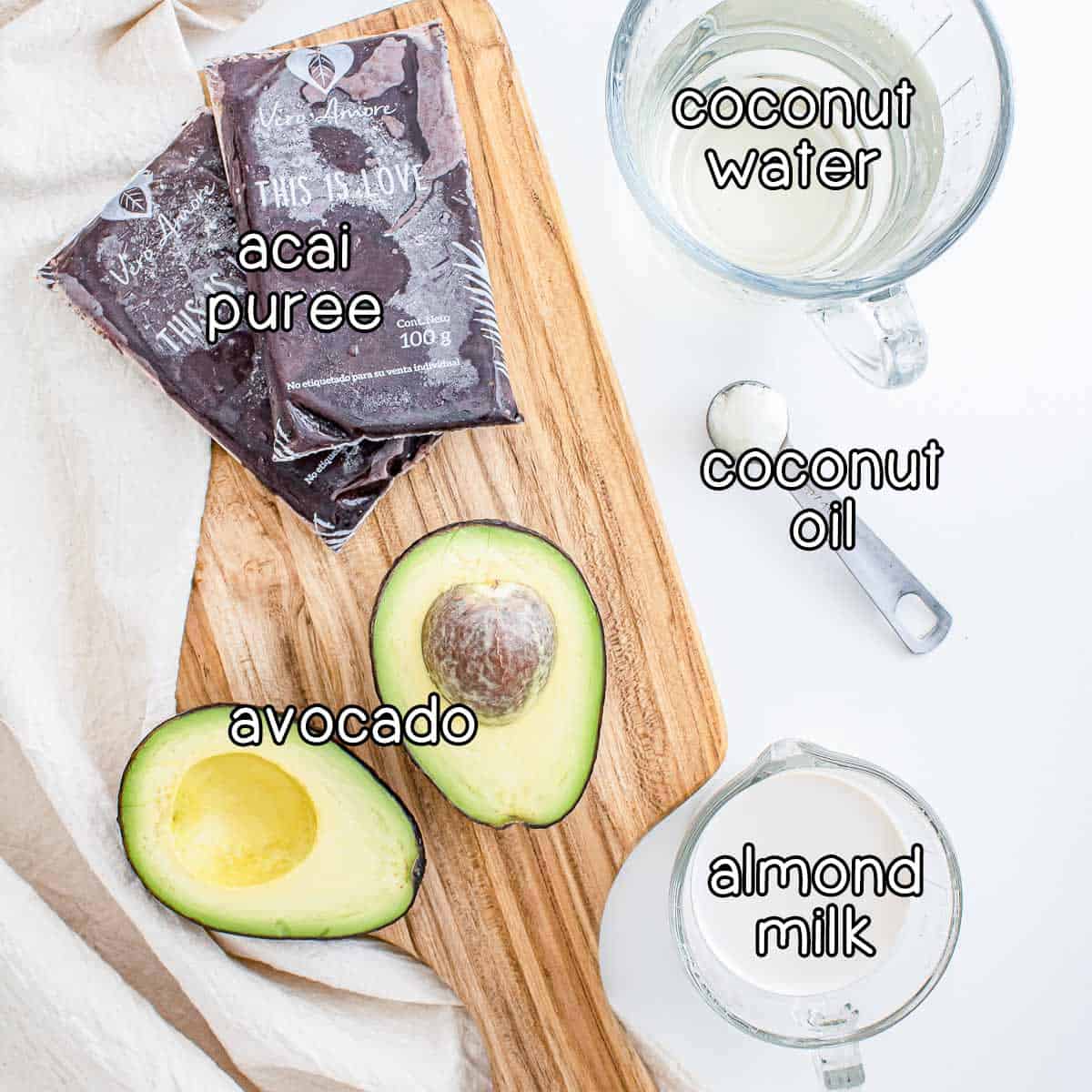 Overhead shot of ingredients- acai puree, coconut water, coconut oil, avocado, and almond milk.