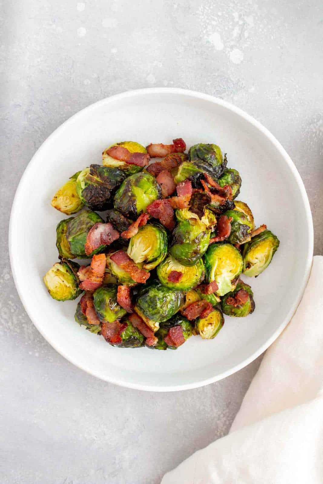 A plate of air fryer brussels sprouts with bacon.