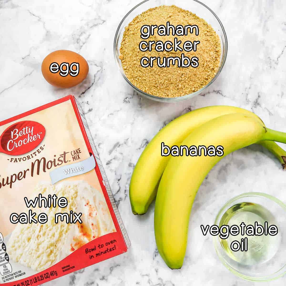 Overhead shot of ingredients - graham cracker crumbs, egg, white cake mix, bananas, and vegetable oil.