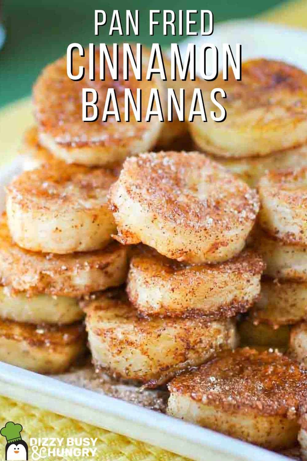 Front view of piled up cinnamon banana snacks on a white dish with a yellow napkin in the foreground and a green napkin in the background.