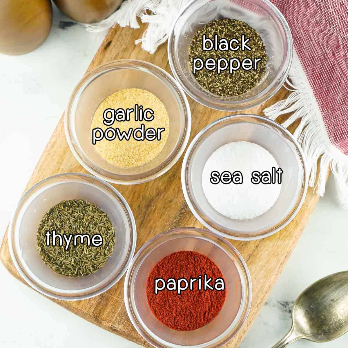 Overhead shot of ingredients - garlic powder, black pepper, sea salt, thyme, and paprika.