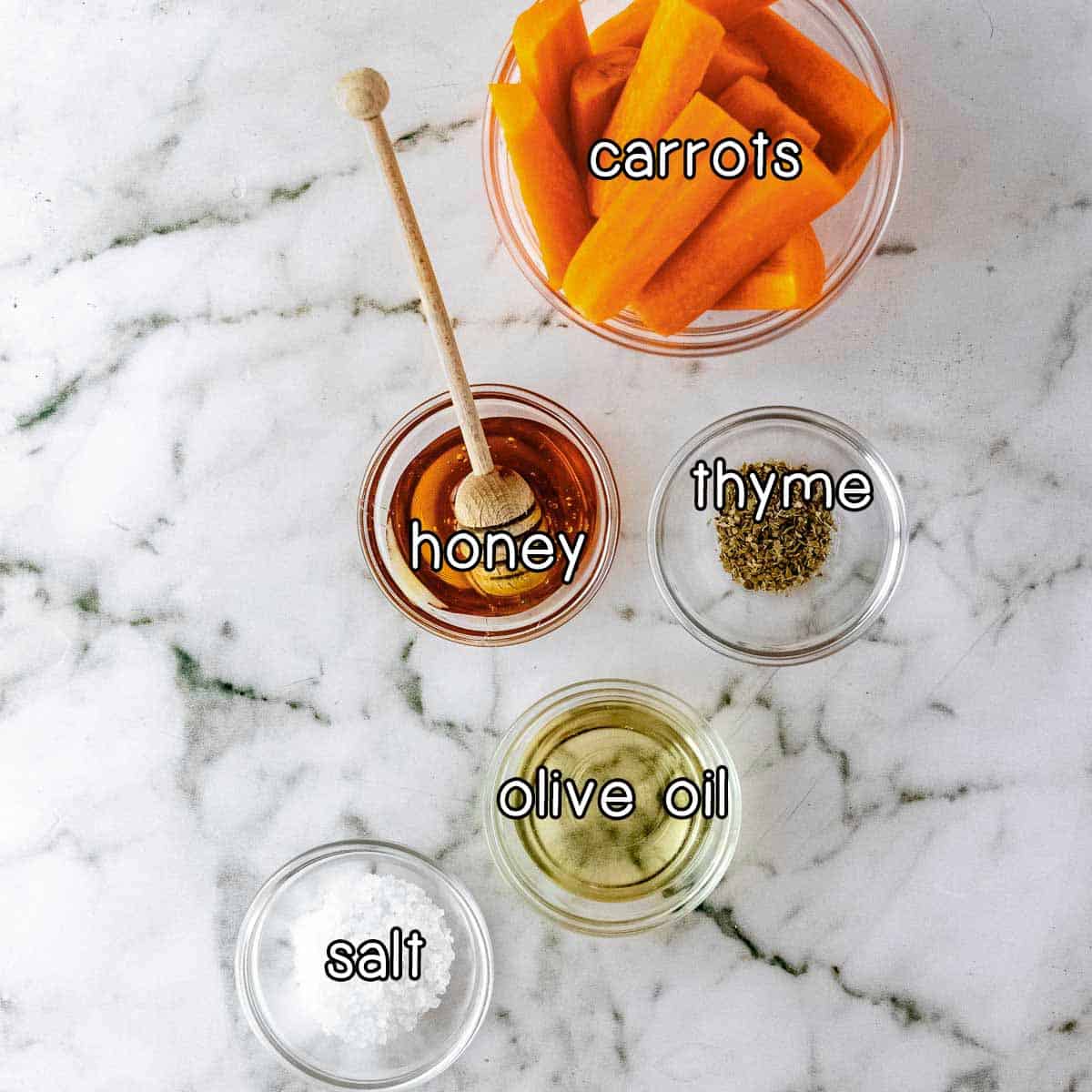 Overhead shot of ingredients - carrots, honey, thyme, olive oil, and salt.