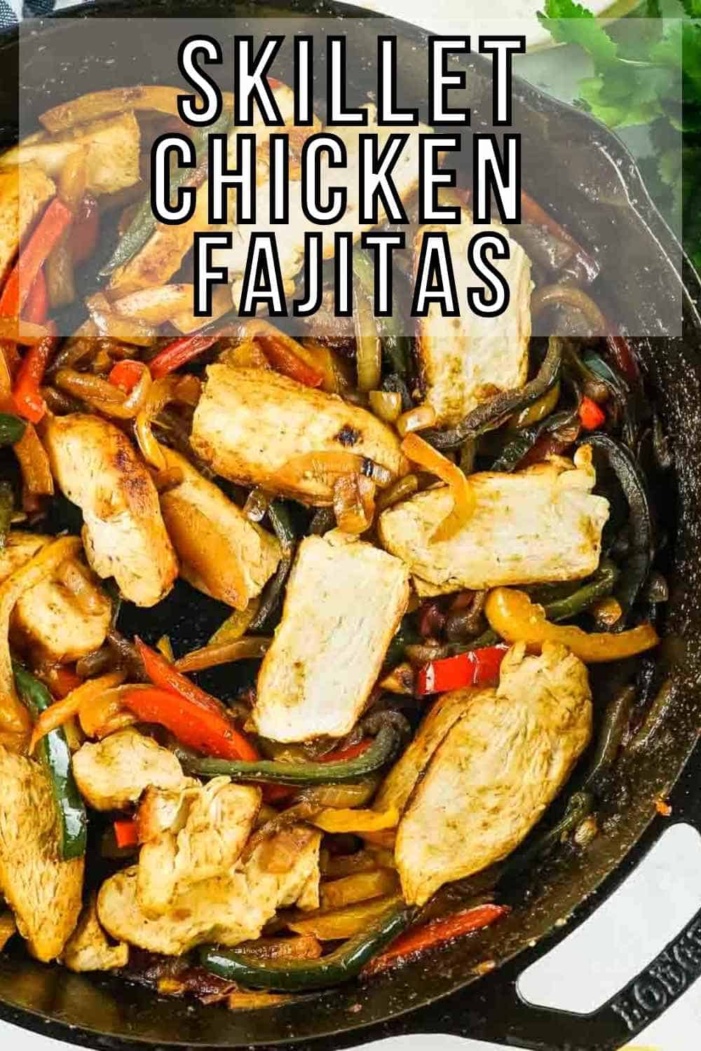 Overhead shot of chicken fajitas in a black skillet with fresh herbs on the side.