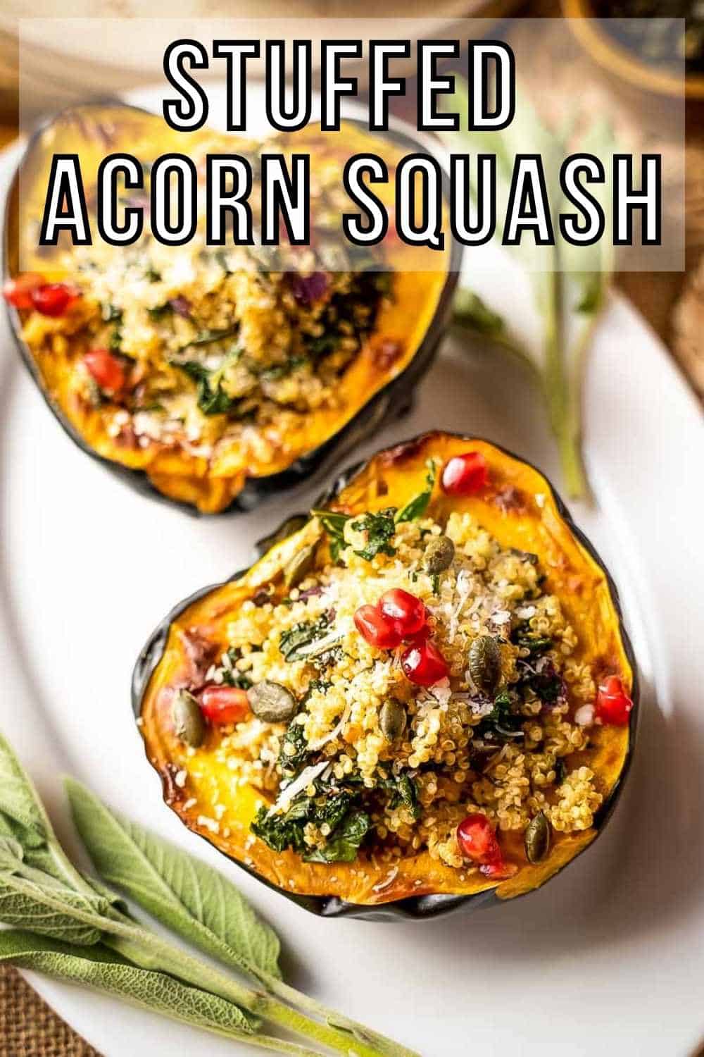 Overhead shot of two halves of an acorn squash filled with quinoa filling on a white oval plate with sage on the side.