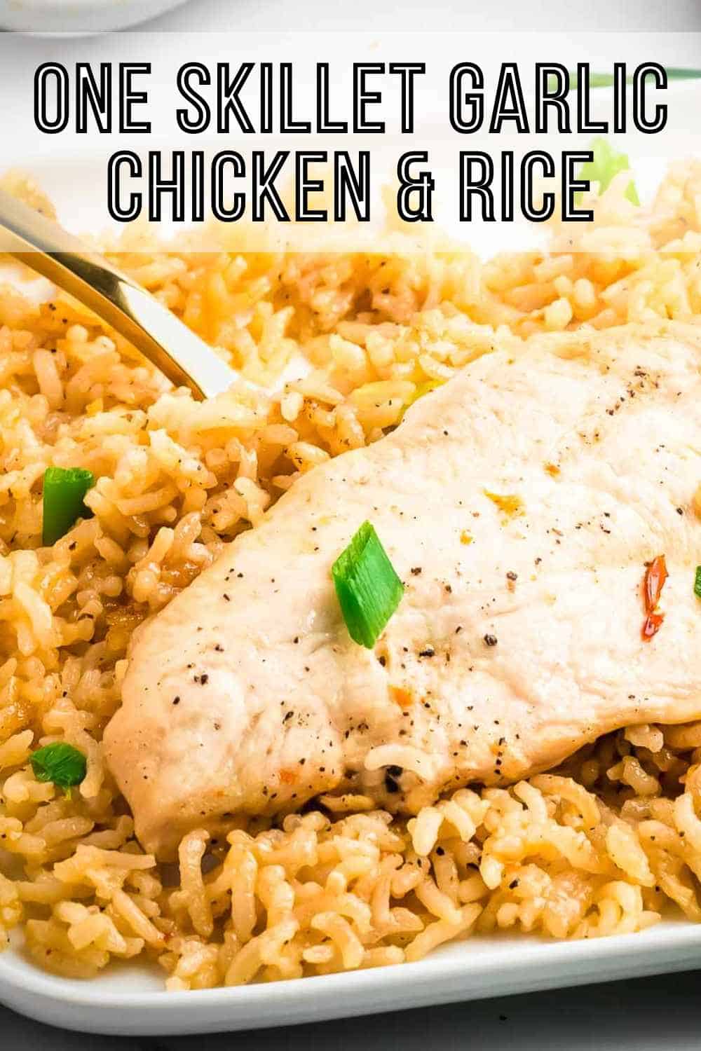 Side shot of a piece of chicken with rice garnished with green onions on a square white plate with a gold fork on the side.