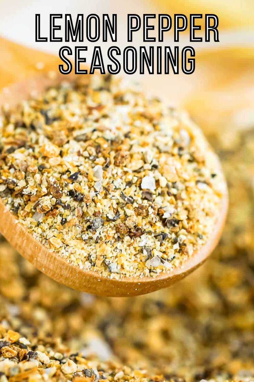 Close up shot of a wooden spoon scooping some seasoning from a clear bowl full of seasoning.