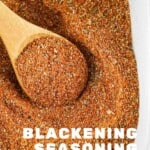Overhead shot of blackened seasoning in a square white bowl with a wooden spoon scooping some seasoning out.