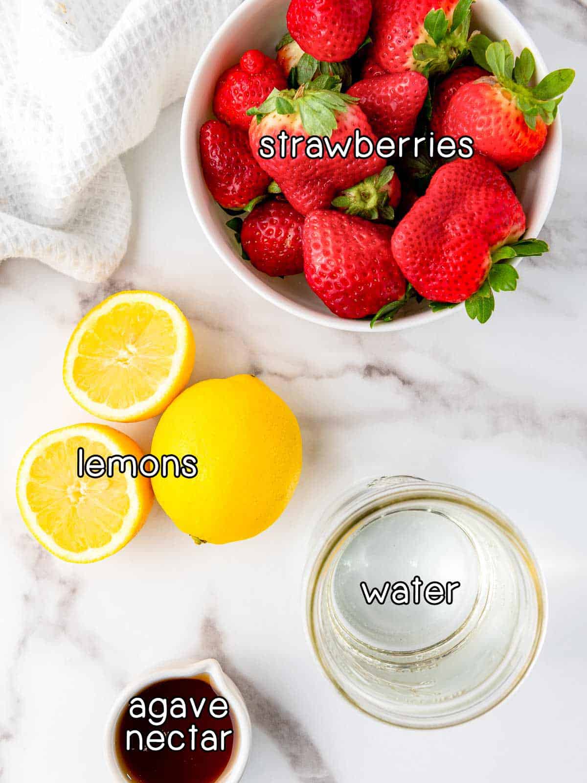 Overhead shot of ingredients - strawberries, lemons, agave nectar, and water.