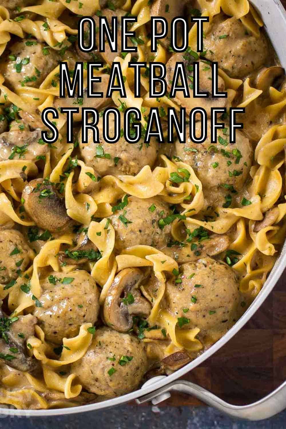 Overhead shot of a large silver pot full of meatball stroganoff on a wooden surface.