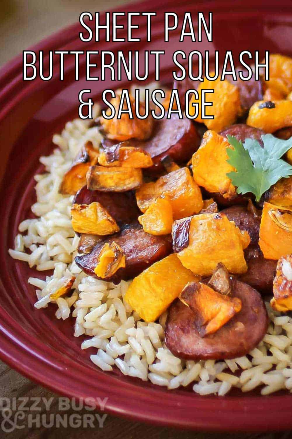 Side close up shot of sausage and butternut squash on a bed of rice on a red plate.