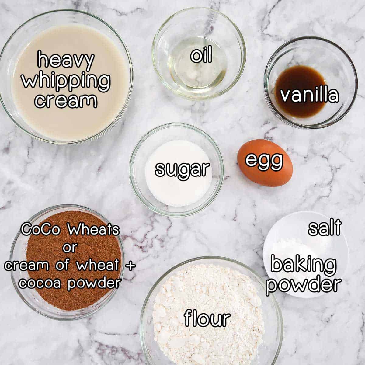 Overhead shot of ingredients - heavy whipping cream, oil, vanilla, sugar, egg, salt, baking powder, flour, and coco wheats (or creamy of wheat + cocoa powder).