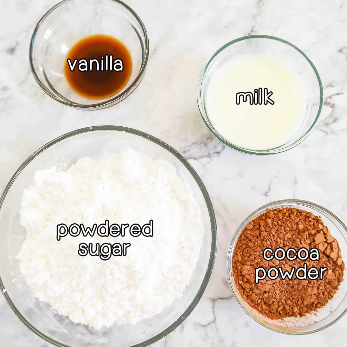 Overhead shot of ingredients - powdered sugar, vanilla, milk, and cocoa powder.