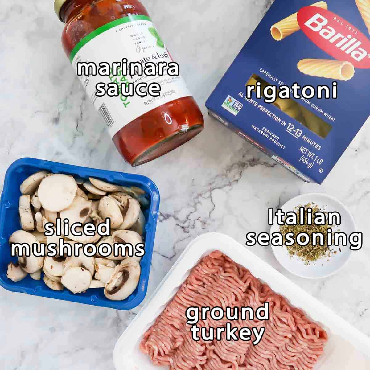 Overhead shot of ingredients - marinara sauce, rigatoni, sliced mushrooms, ground turkey, and Italian seasoning.