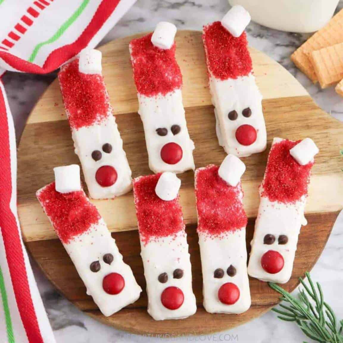 Rectangular wafer cookies decorated with red and white candy to look like Santa.