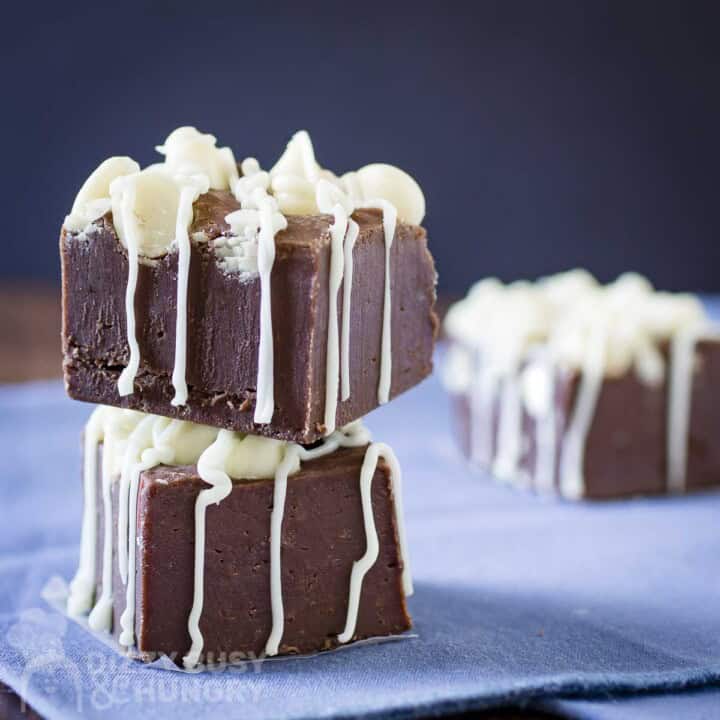 Side view of two pieces of fudge stacked on top of each other on a blue napkin.