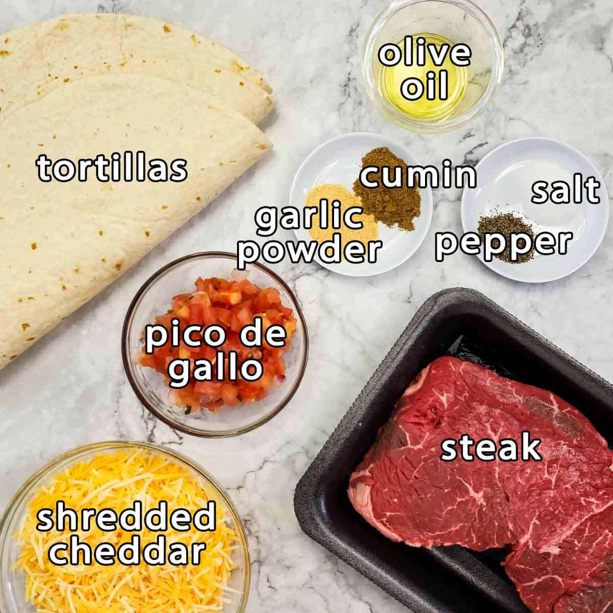 Overhead shot of ingredients - tortillas, olive oil, pico de gallo, shredded cheddar, steak, garlic powder, cumin, pepper, and salt.