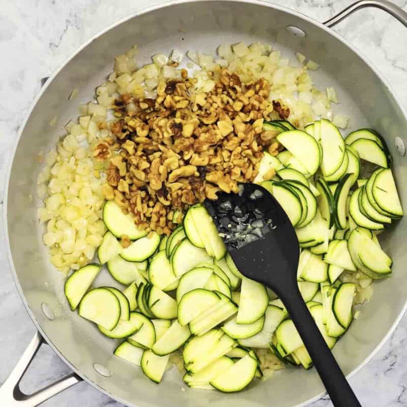 Overhead view of process shot 3 - add the zucchini and walnuts and saute for about 2 minutes.