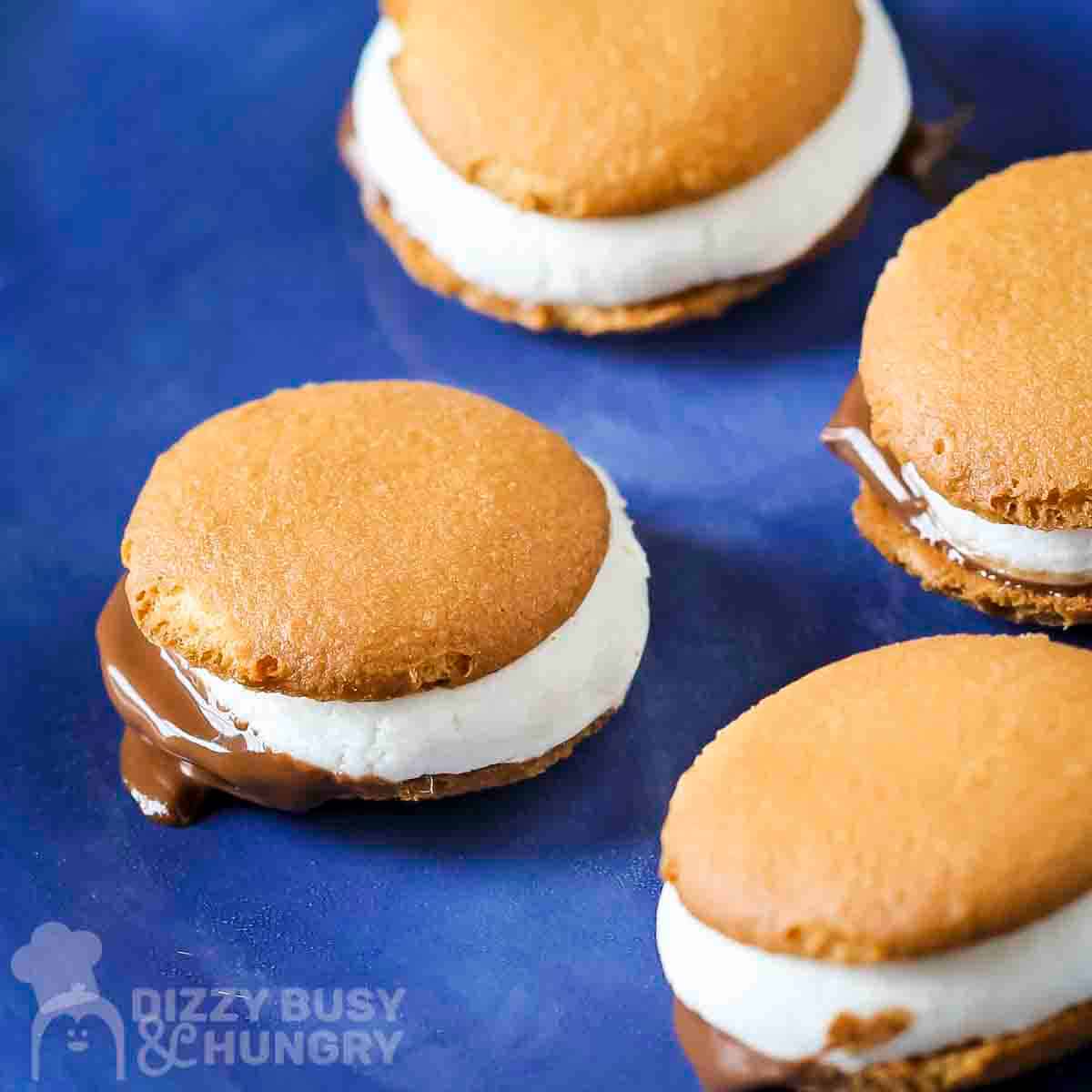 Side shot of multiple microwave s'mores on a blue plate.