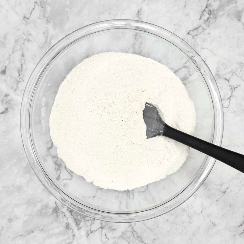 Overhead view of pancakes process shot 1 - in a very large bowl, combine the flour, baking powder, salt, and sugar.