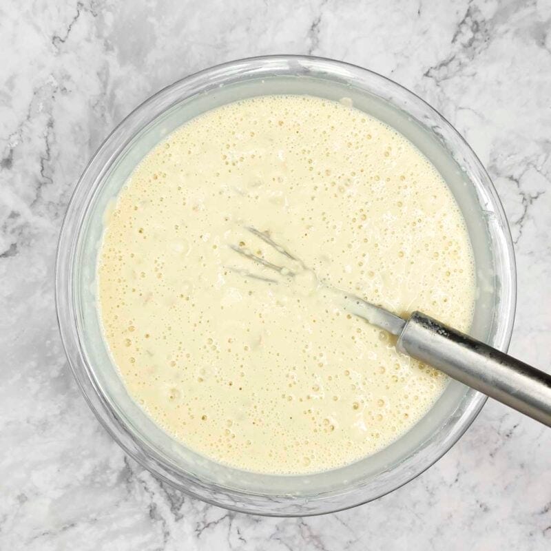 Overhead view of pancakes process shot 4 - add the liquid ingredients to the dry ingredients and mix together.