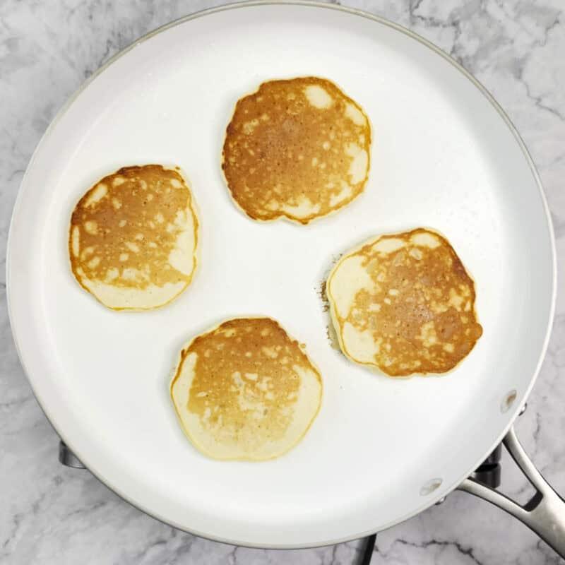 Overhead view of pancakes process shot 6 - cook until the edges start to look dry and the pancakes start to bubble. Then flip and cook on the other side.