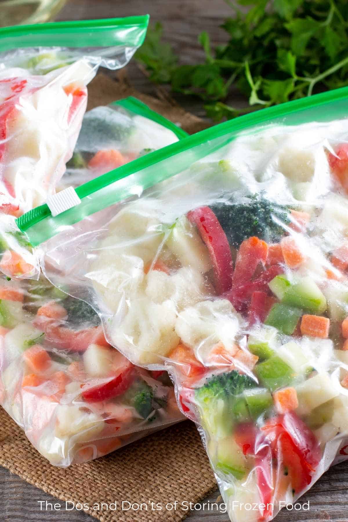 Using clear zip top freezer bags for storing frozen food such as colorful chopped vegetables.
