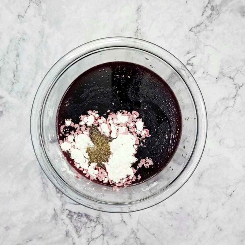 Overhead view of process shot 1 - in a medium bowl, combine the french onion soup, red wine, salt, pepper, and cornstarch.