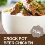 Side shot of beer chicken on a bed of rice in a white bowl garnished with fresh herbs.