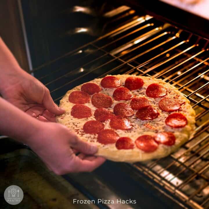 Photo of a person sliding a frozen pizza onto the oven rack.