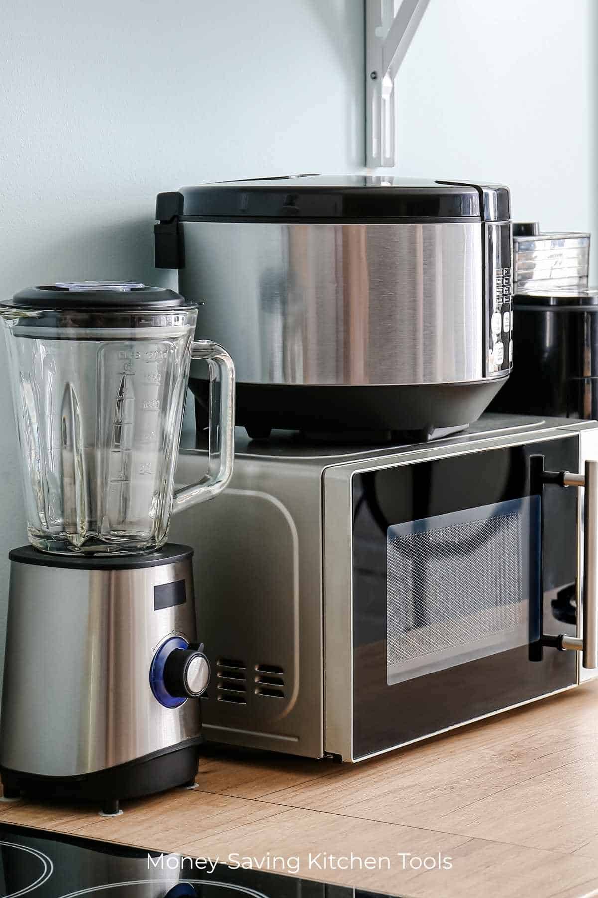 Photo of a blender, microwave, instant pot, and other small kitchen appliances on a wood counter.