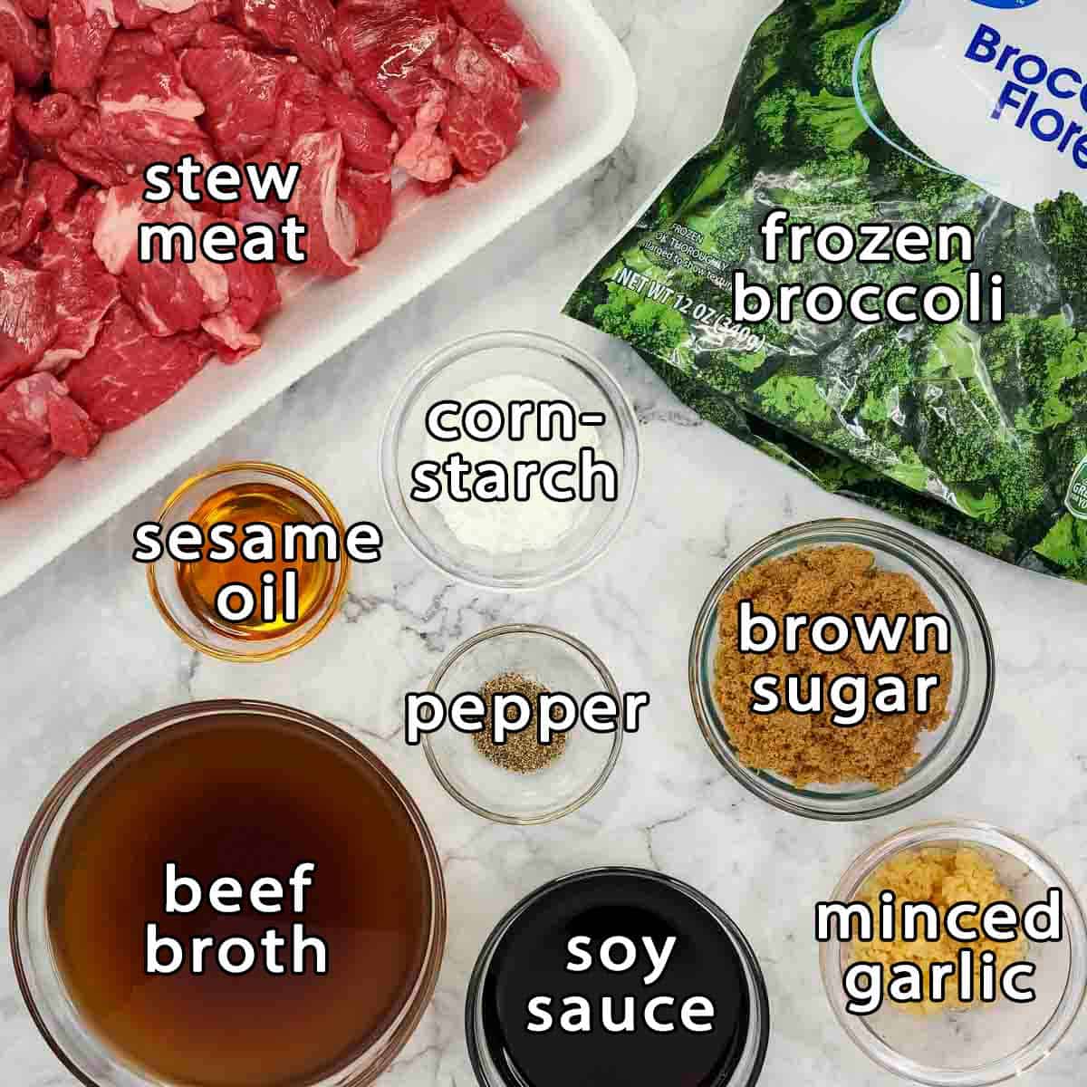 Overhead shot of ingredients - stew meat, frozen broccoli, sesame oil, cornstarch, beef broth, brown sugar, soy sauce, minced garlic, and pepper.