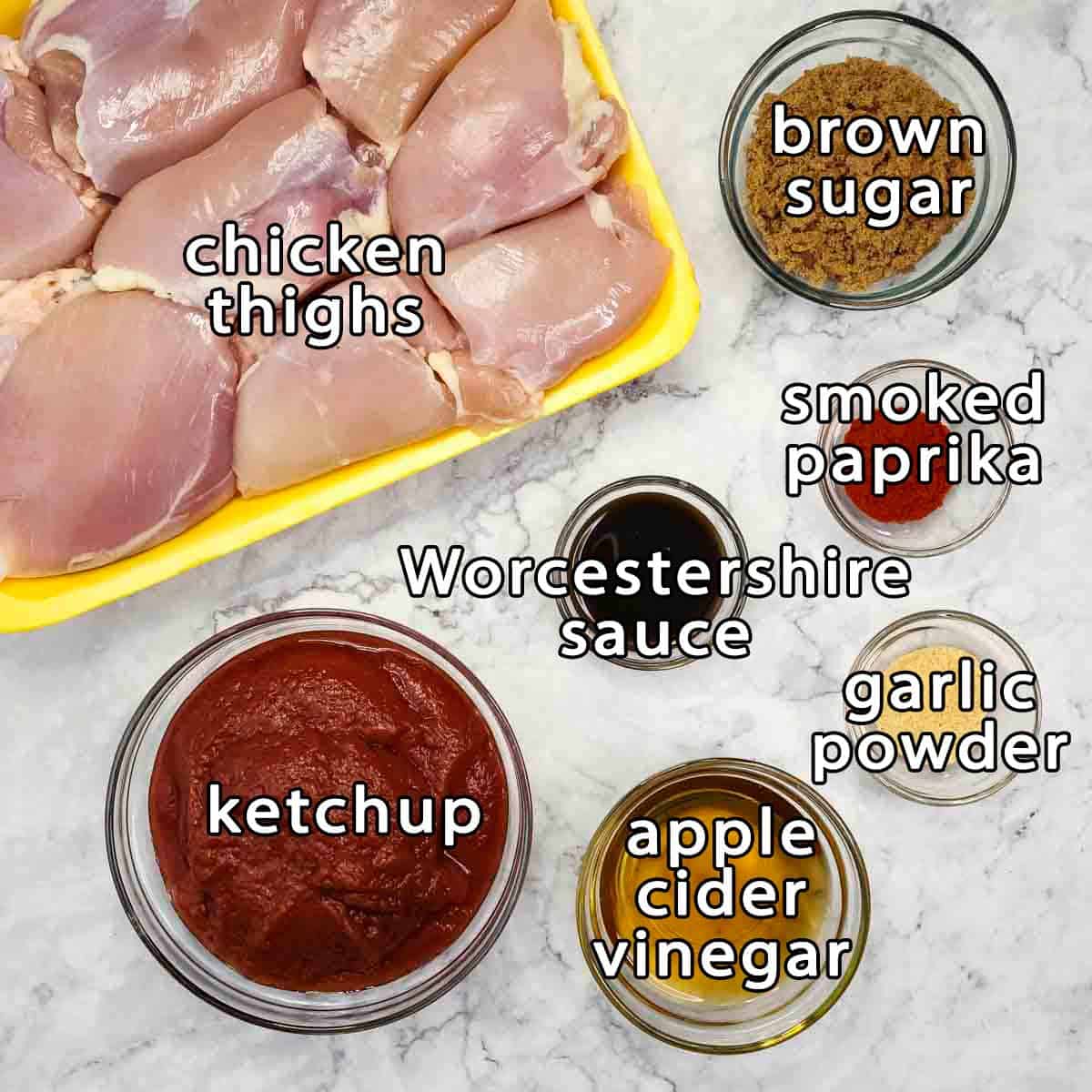 Overhead shot of ingredients - chicken thighs, brown sugar, ketchup, worcestershire sauce, smoked paprika, garlic powder, and apple cider vinegar.