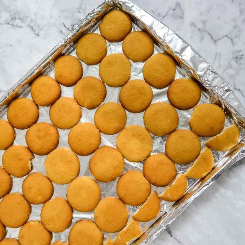 Overhead view of process shot 1 - line a jelly roll pan with aluminum foil and spray with non-stick cooking spray. Place the vanilla wafers on the sheet in rows, touching each other.