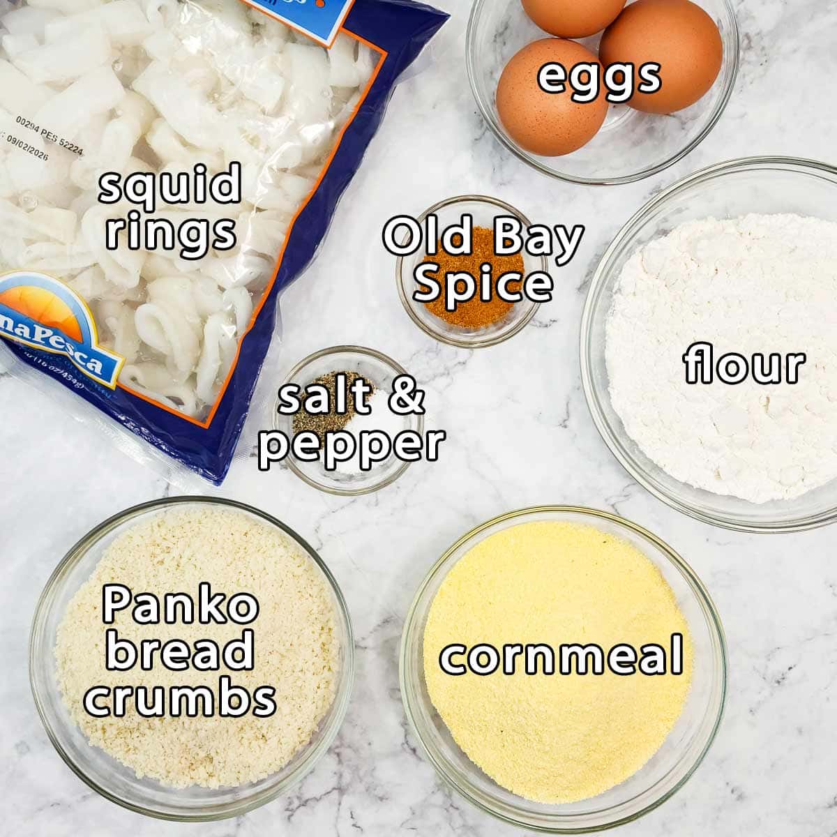 Overhead shot of ingredients - squid rings, eggs, flour, cornmeal, panko bread crumbs, old bay spice, and salt & pepper.