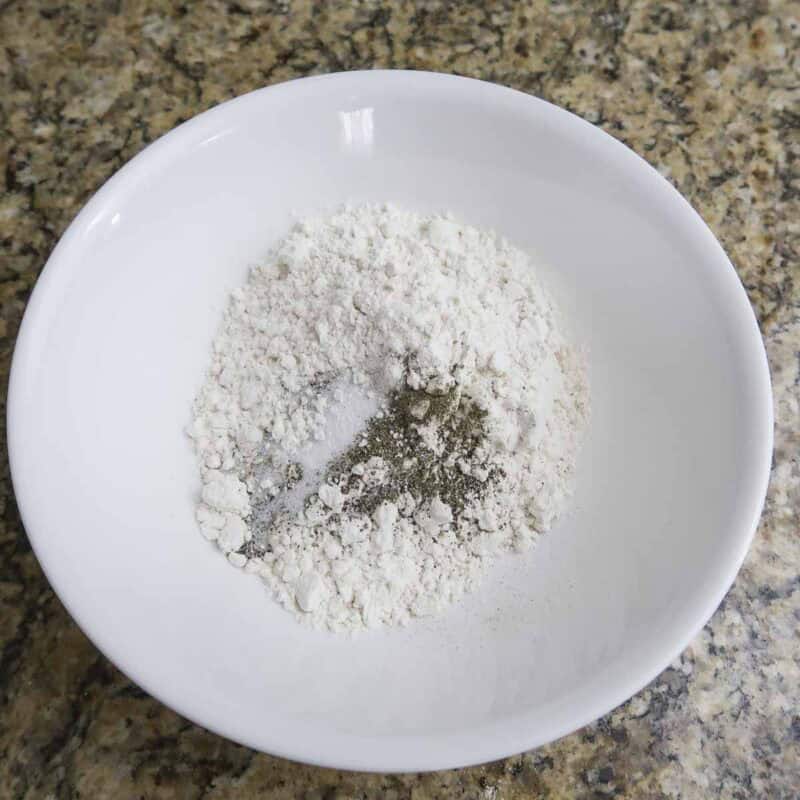 Overhead view of process shot 1 - Combine the flour, salt, and pepper in a large bowl.