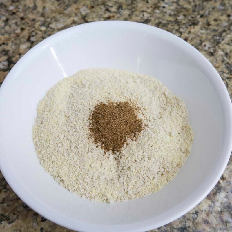 Overhead view of process shot 3 - In a third bowl, combine bread crumbs, cornmeal, and old bay seasoning.
