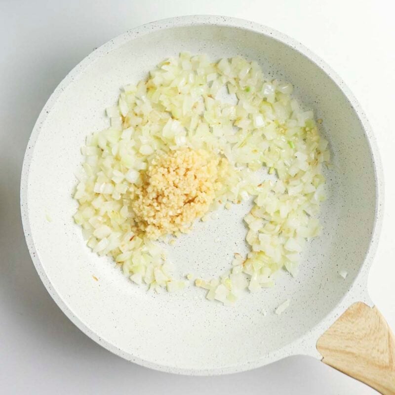 Overhead view of process shot 1 - in a skillet over medium heat, heat the olive oil and saute the onion until softened, about 3 minutes. Add the garlic and cook for 30 seconds more.