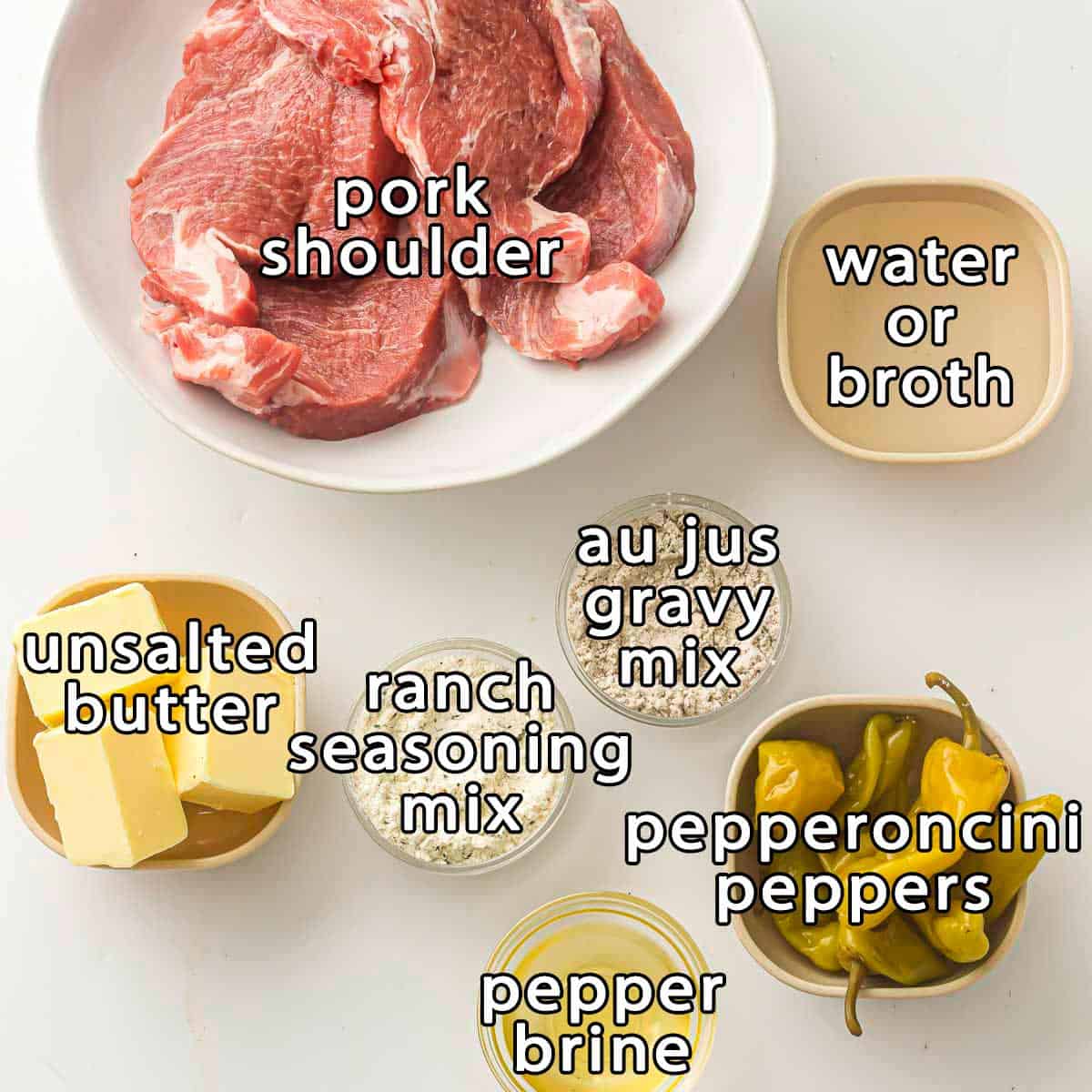 Overhead shot of ingredients - pork shoulder, water or broth, au jus gravy mix, ranch seasoning mix, unsalted butter, pepper brine, and pepperoncini peppers.