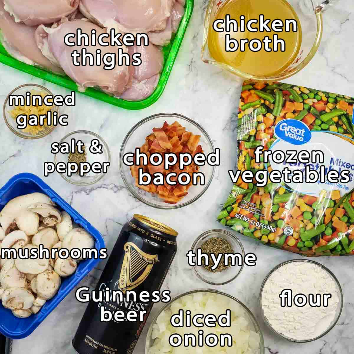 Overhead shot of ingredients - chicken thighs, chicken broth, frozen vegetables, chopped bacon, mushrooms, guinness beer, diced onion, minced garlic, flour, thyme, salt, and pepper.