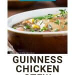 Side shot of chicken stew garnished with fresh thyme in a white oval bowl on a wooden surface.
