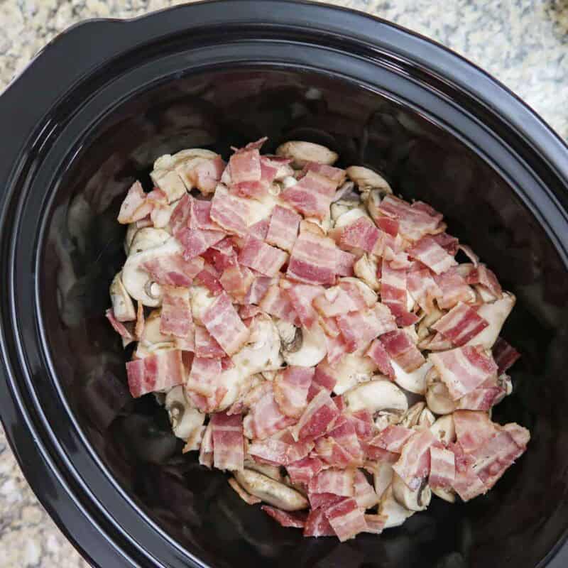 Overhead view of process shot 2 - distribute the bacon and mushrooms over the chicken.