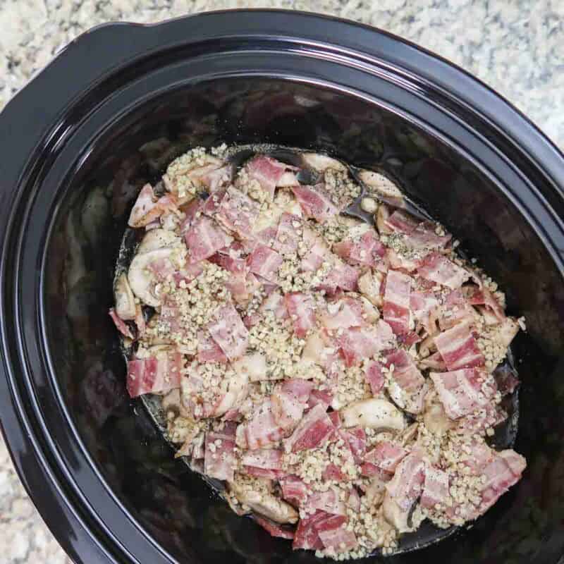 Overhead view of process shot 3 - in a separate bowl, combine the guinness, broth, garlic, pepper, salt, and thyme. Pour the mixture over the children and cover. Cook on high for 3-4 hours or low 6-7 hours.