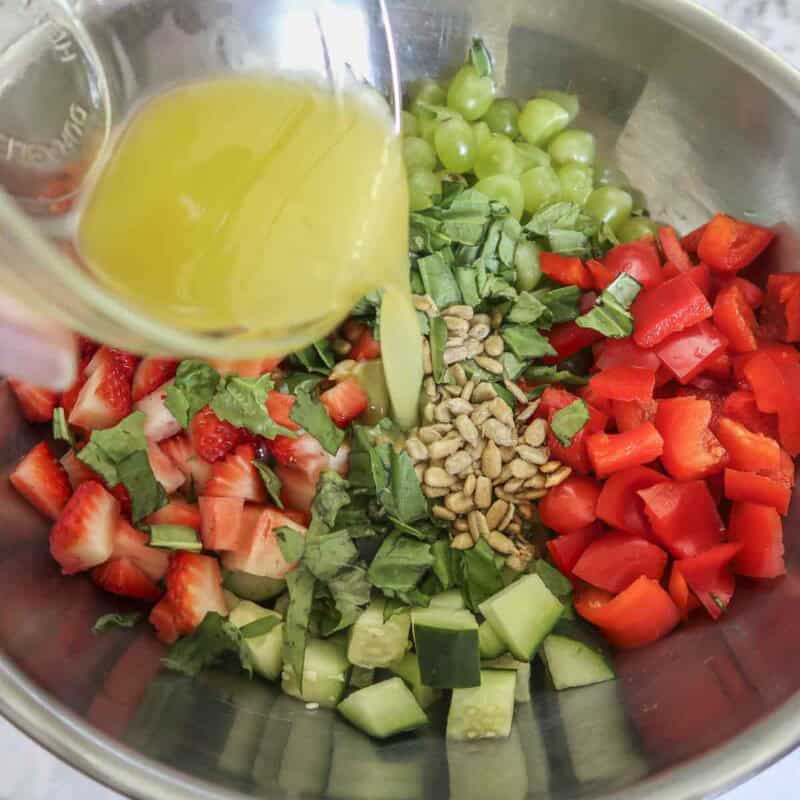 Side view of process shot 3 - pour the dressing into the bowl.