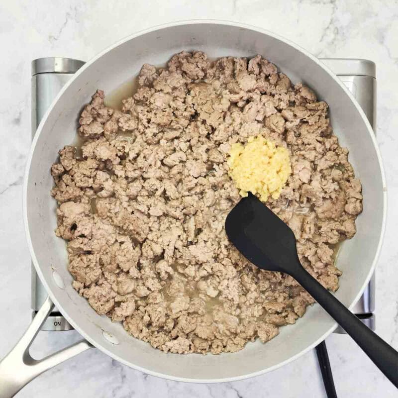 Overhead view of process shot 2 - add the garlic to the pan and cook for 30 seconds.