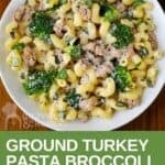 Overhead shot of turkey and broccoli pasta sprinkled wiith parmesan cheese in a white bowl.