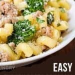 Side shot of turkey and broccoli pasta sprinkled wiith parmesan cheese in a white bowl.