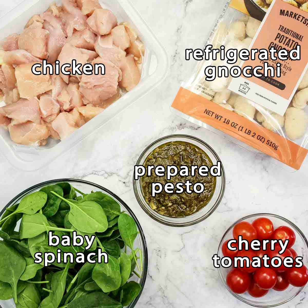 Overhead shot of ingredients - chicken, refrigerated gnocchi, prepared pesto, baby spinach, and cherry tomatoes.