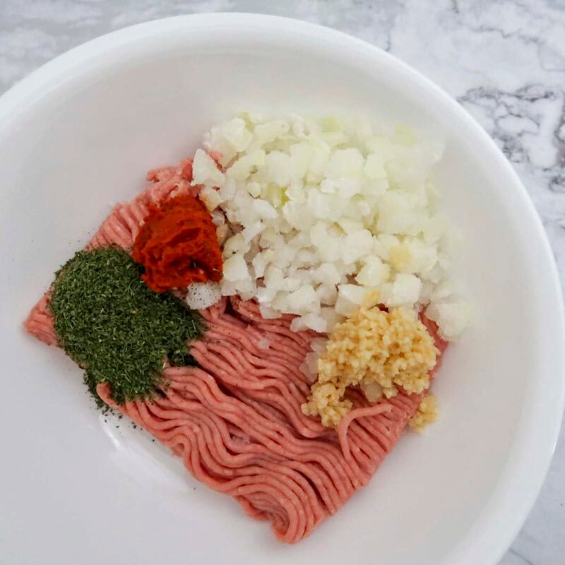Overhead view of burger process shot 1 - combine the burger ingredients in a bowl.