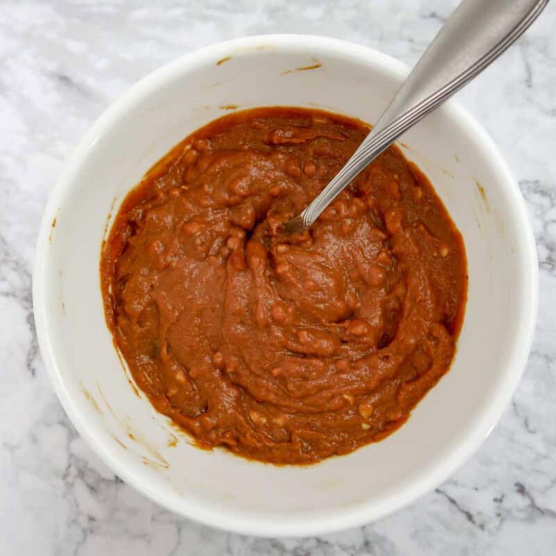Overhead view of peanut sauce process shot 1 - combine the peanut butter, soy sauce, honey, chili paste, and lime juice in a bowl.