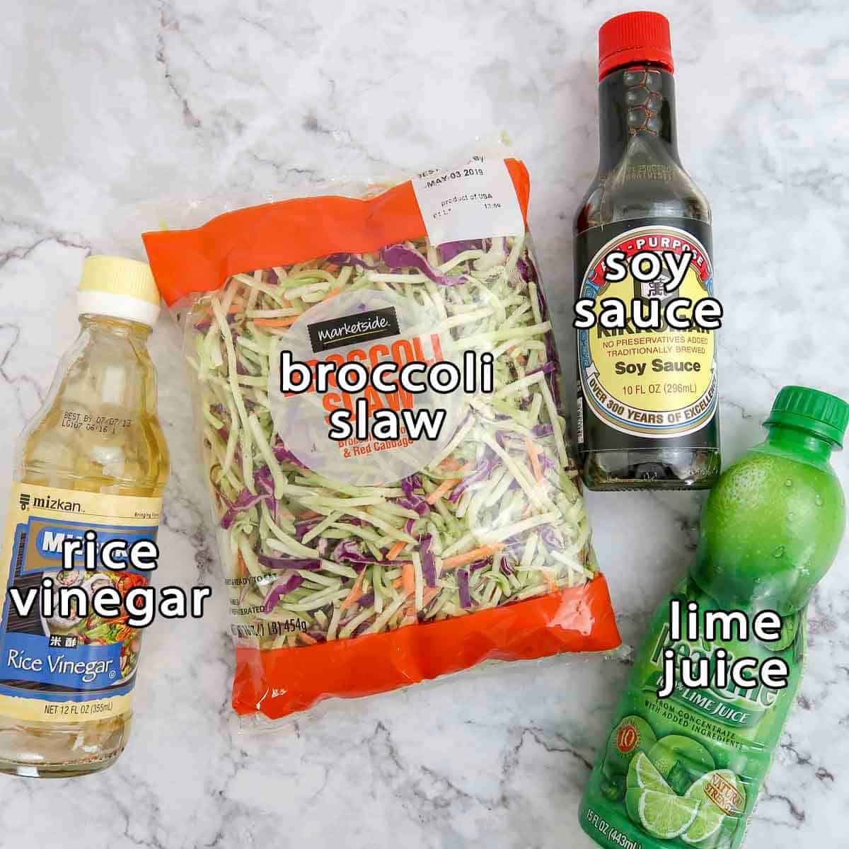 Overhead shot of slaw ingredients - rice vinegar, broccoli slaw, soy sauce, and lime juice.